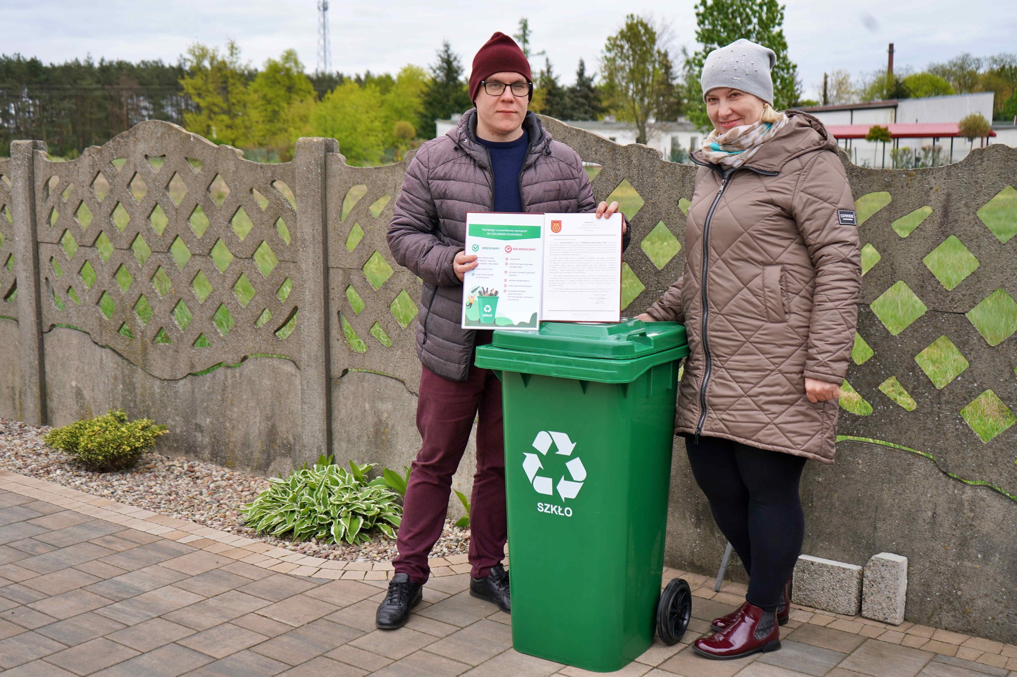 Radny Miejski Adrian Król przekazuje mieszkańce Koła zielony pojemnik do selektywnej zbiórki odpadów