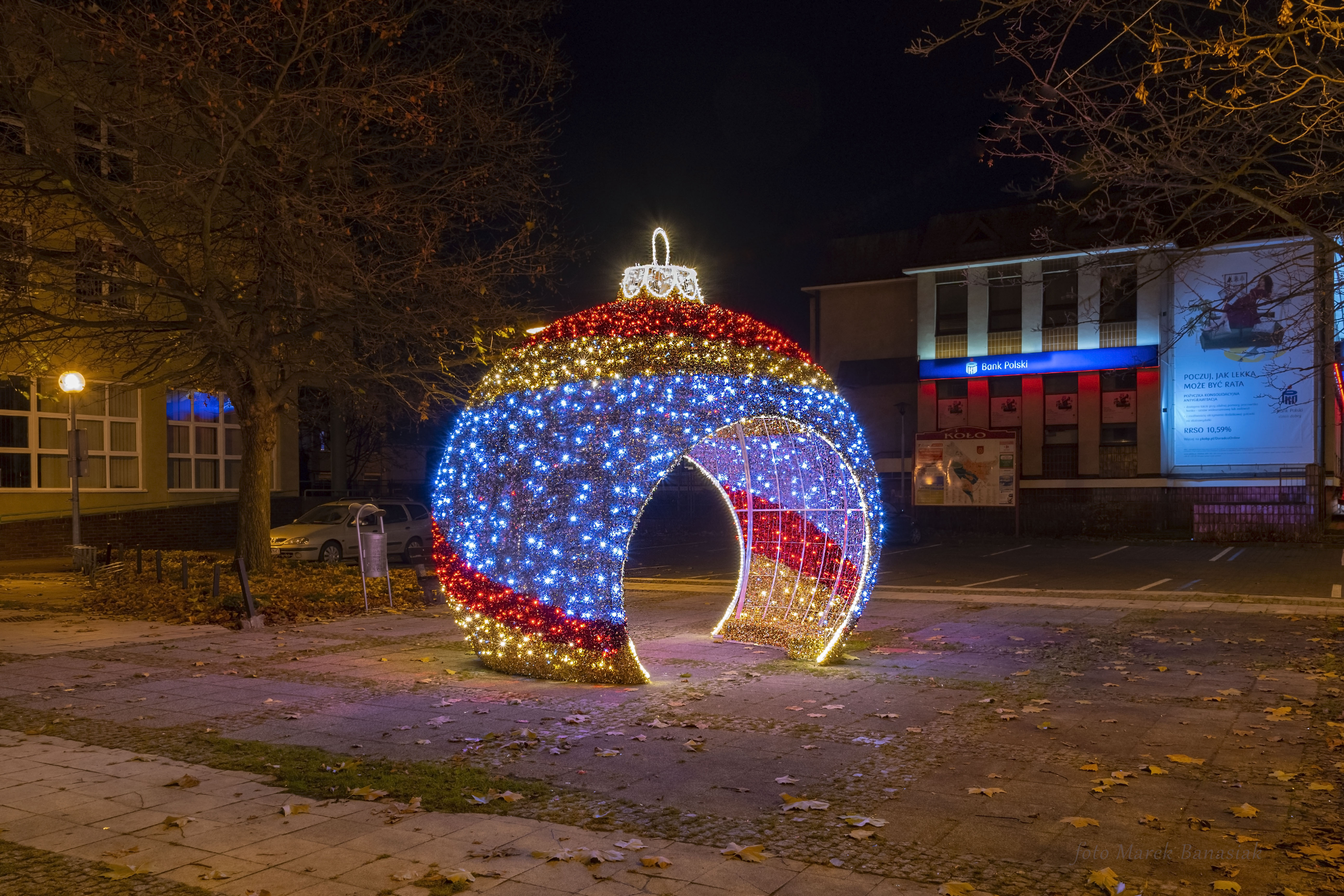 Zdjęcie przedstawia kolorową bombkę z iluminacjami świetlnymi przed Urzędem Skarbowym w Kole.