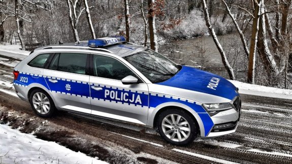 Zdjęcie przedstawia wóz policyjny na oblodzonej jezdni.