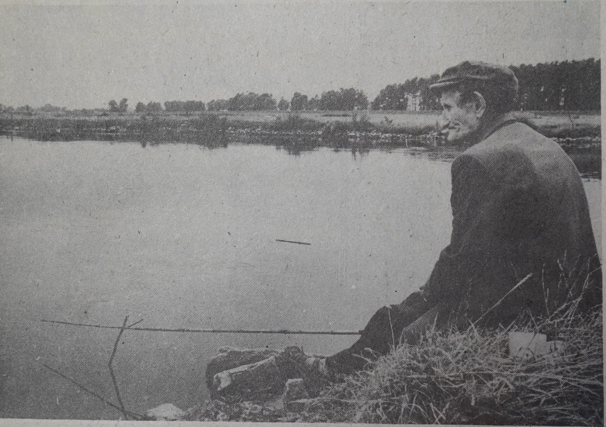 Archiwalne zdjęcie siedzącego starszego mężczyzny łowiącego kijem leszczynowym nad brzegiem Warty