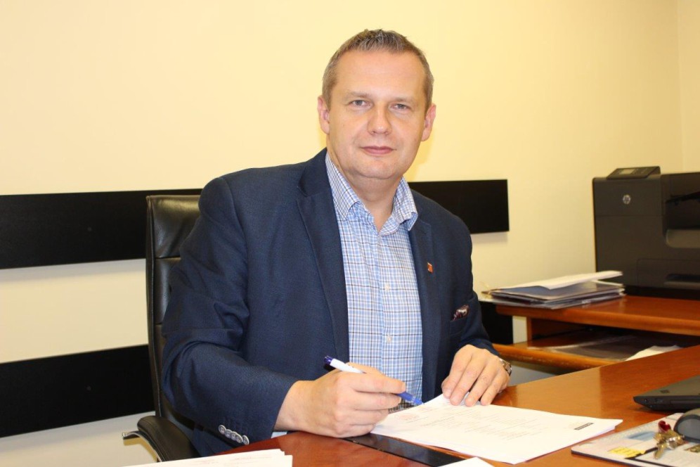 Zdjęcie przedstawia Burmistrza Miasta Koła podpisującego dokumnety.