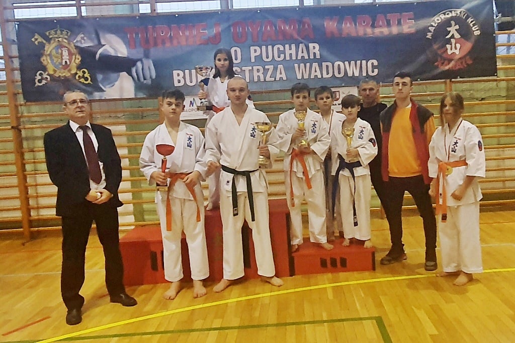 Zdjęcie przedstawia zawodników KKSW na podium z pucharami i dyplomami wraz z opiekunem.