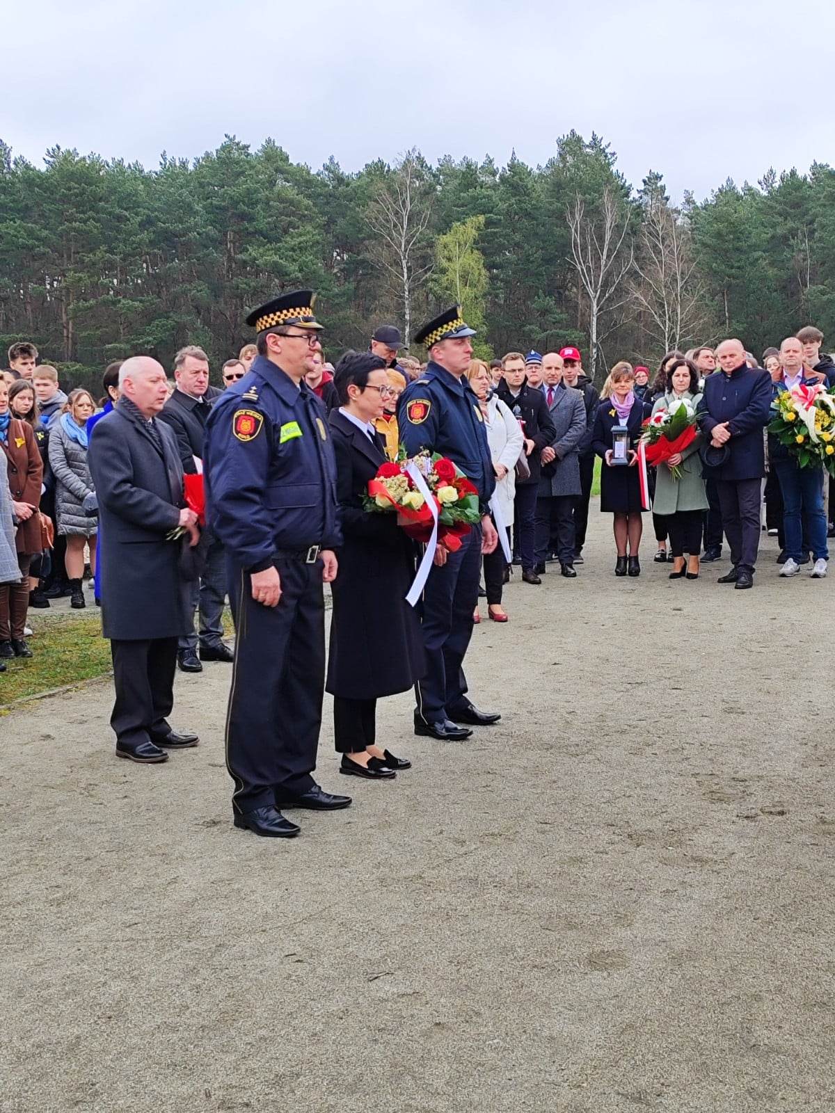 Sekretarz Miasta Monika Ciesielska i Komendant Straży Miejskiej składają wiązanki kwiatów
