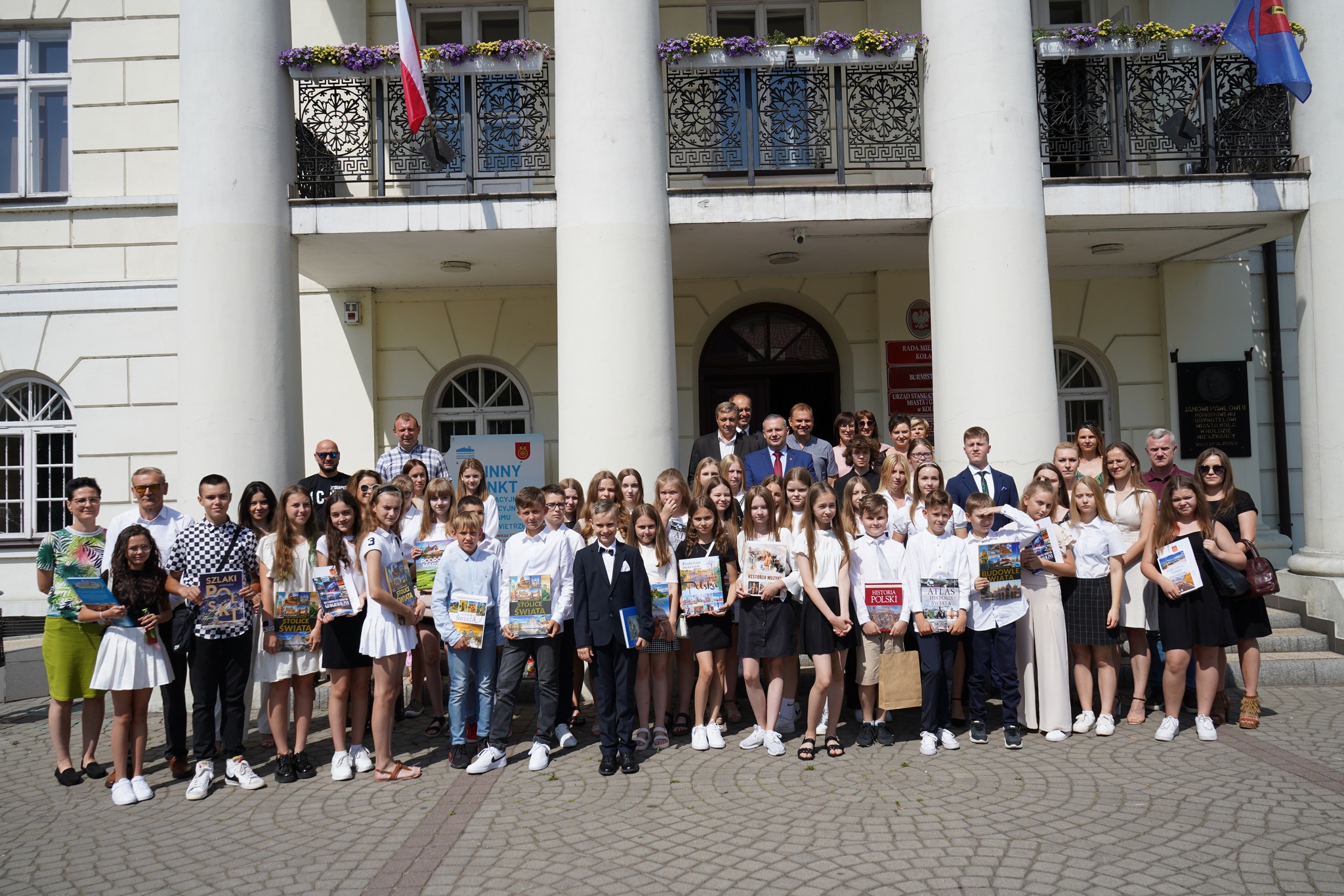 Zdjęcie grupowe nagrodzonych uczniów z Burmistrzem Miasta Koła Krzysztofem Witkowskim przed Ratuszem