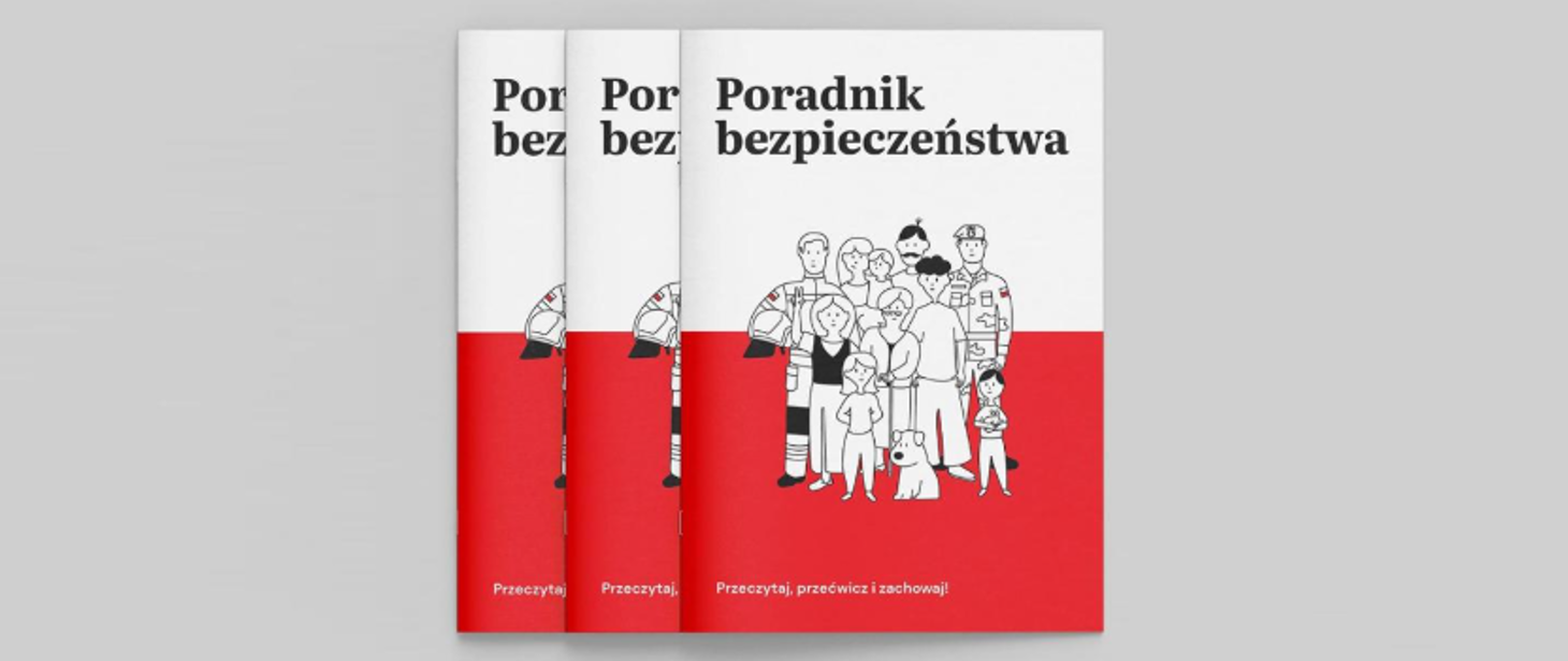 Na zdjęciu widać trzy egzemplarze broszury zatytułowanej „Poradnik bezpieczeństwa” z ilustracją przedstawiającą grupę ludzi, w tym ratownika, żołnierza, dzieci i psa.