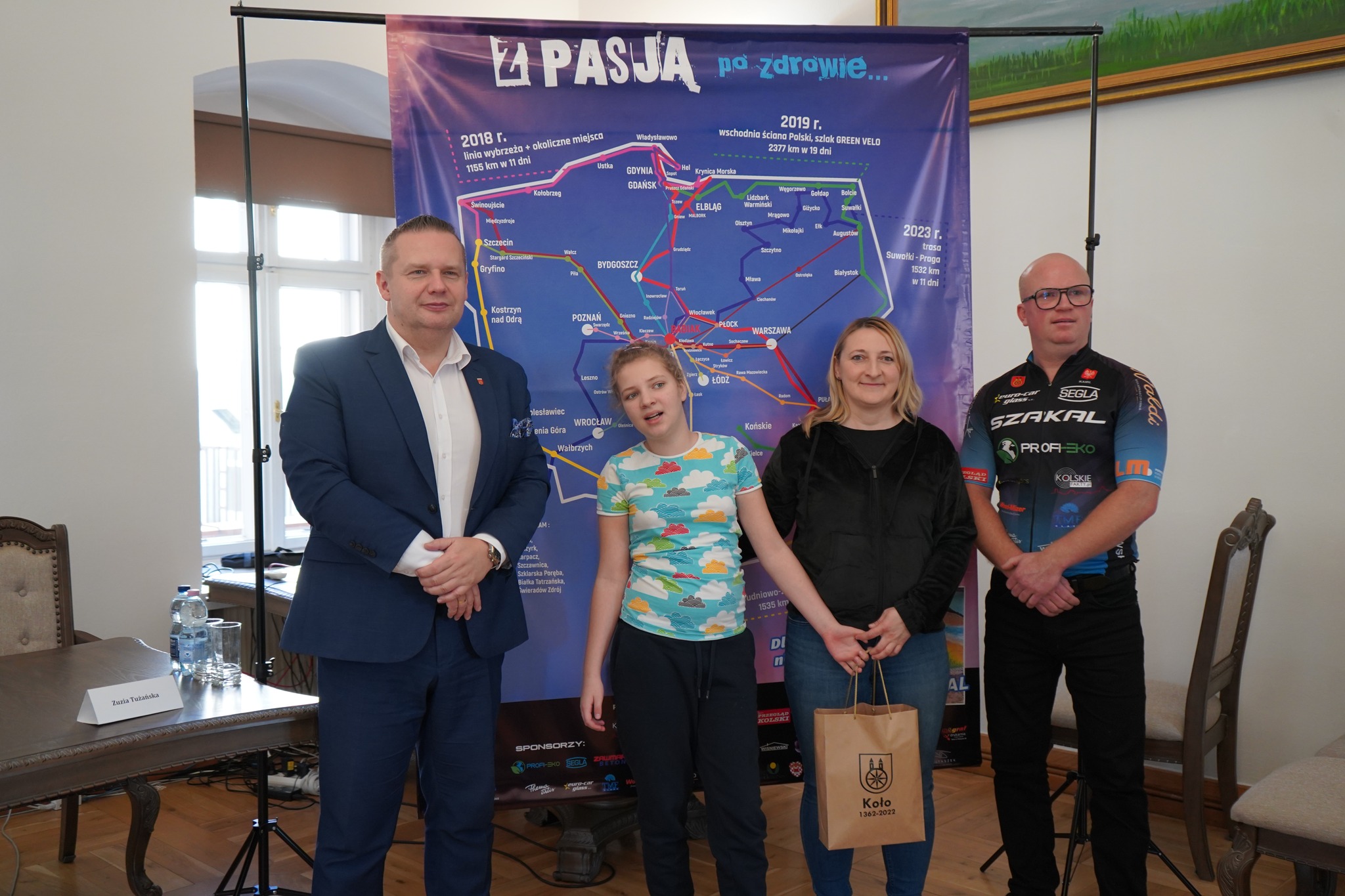 Burmistrz Krzysztof Witkowski, Kamil Jaroszewski, Zuzia z mamą, w tle baner z pasją po zdrowie