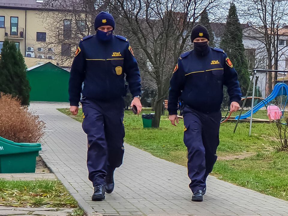 Zdjęcie przedstawia dwóch strażników miejskich podczas patrolu.