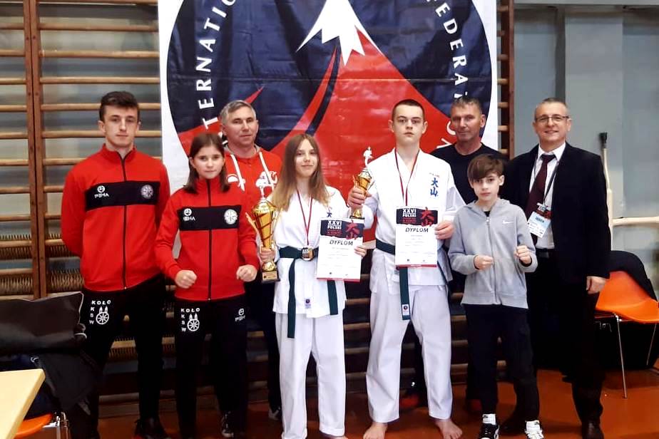 Zawodnicy Kolskiego Klubu Sportów Walki z pucharami i dyplomami wraz z opiekunem.