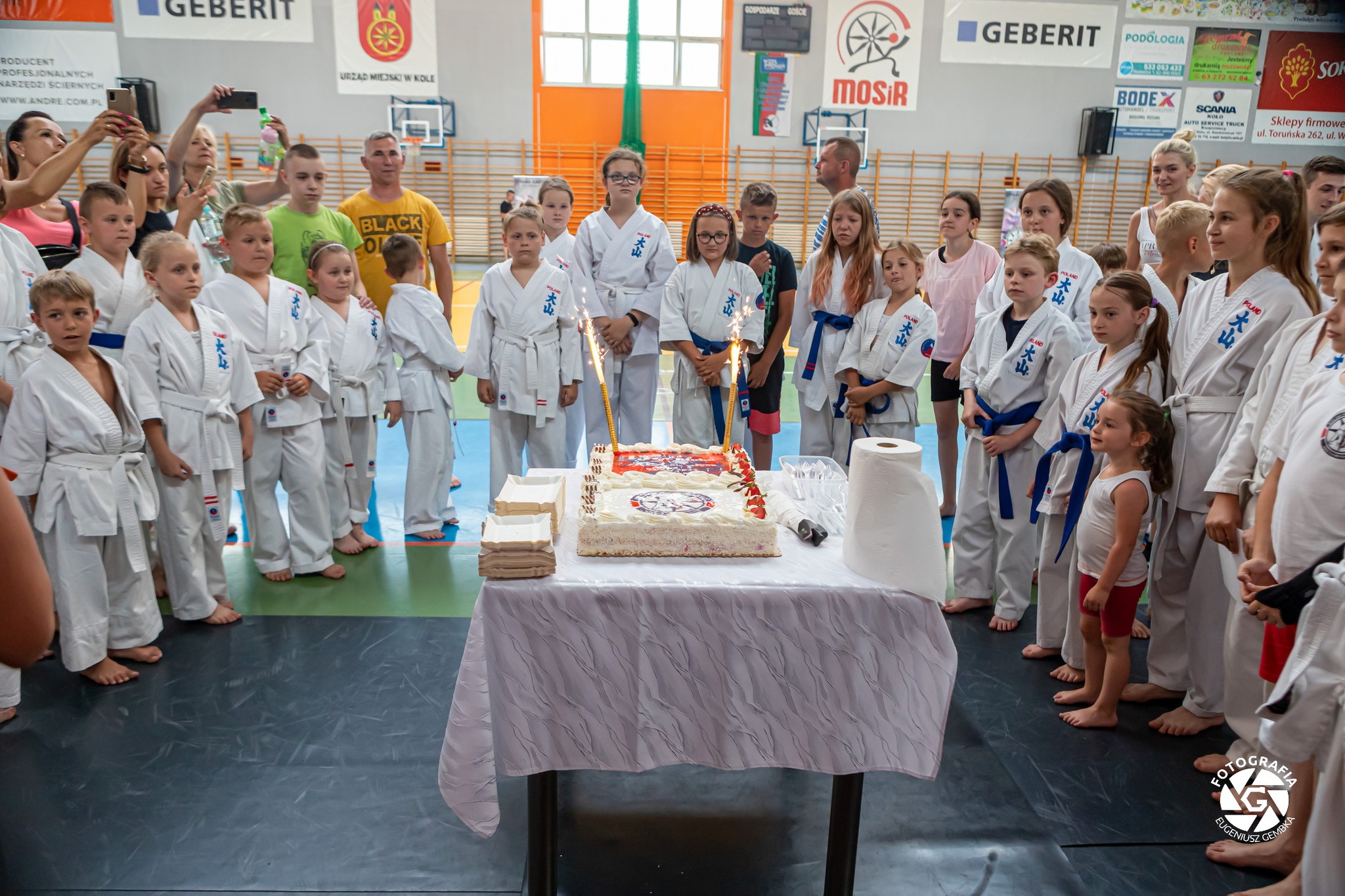 Członkowie Kolskiego Klubu Sportów Walki przy okazjonalnym torcie w hali sportowej w Kole