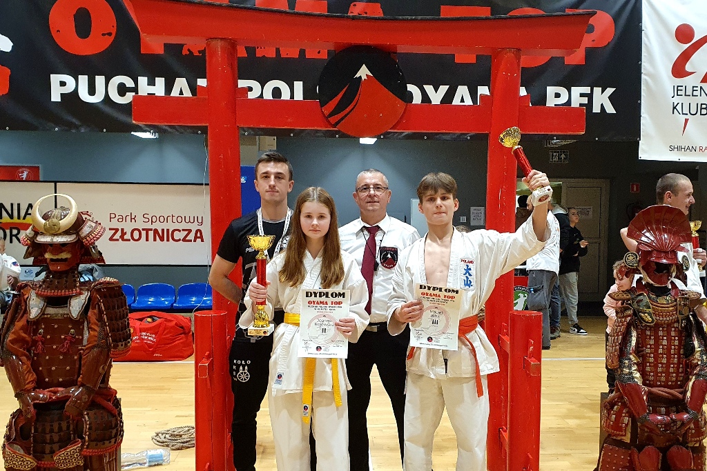 Zawodnicy Kolskiego Klubu Sportów Walki z pucharami i dyplomami wraz z opiekunem.
