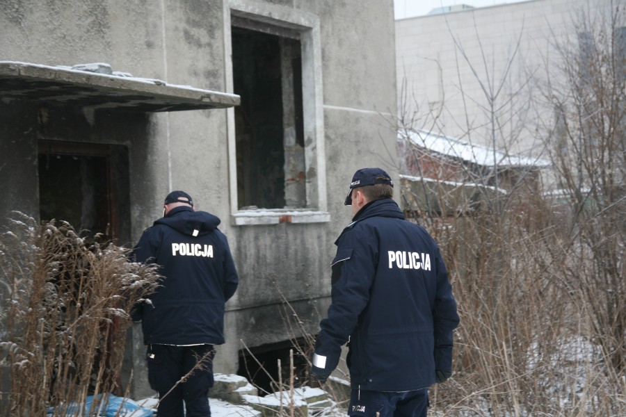 Zdjęcie przedstawia dwóch policjantów sprawdzających pustostan.