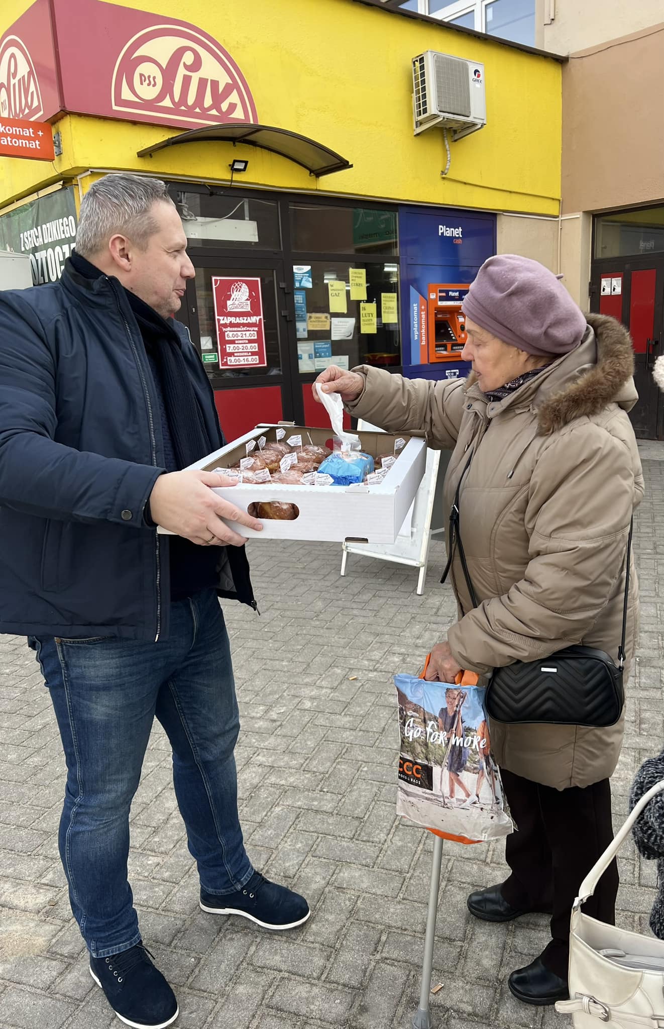 Burmistrz Miasta Koła Krzysztof Witkowski częstuje pączkami mieszkańców miasta Koła