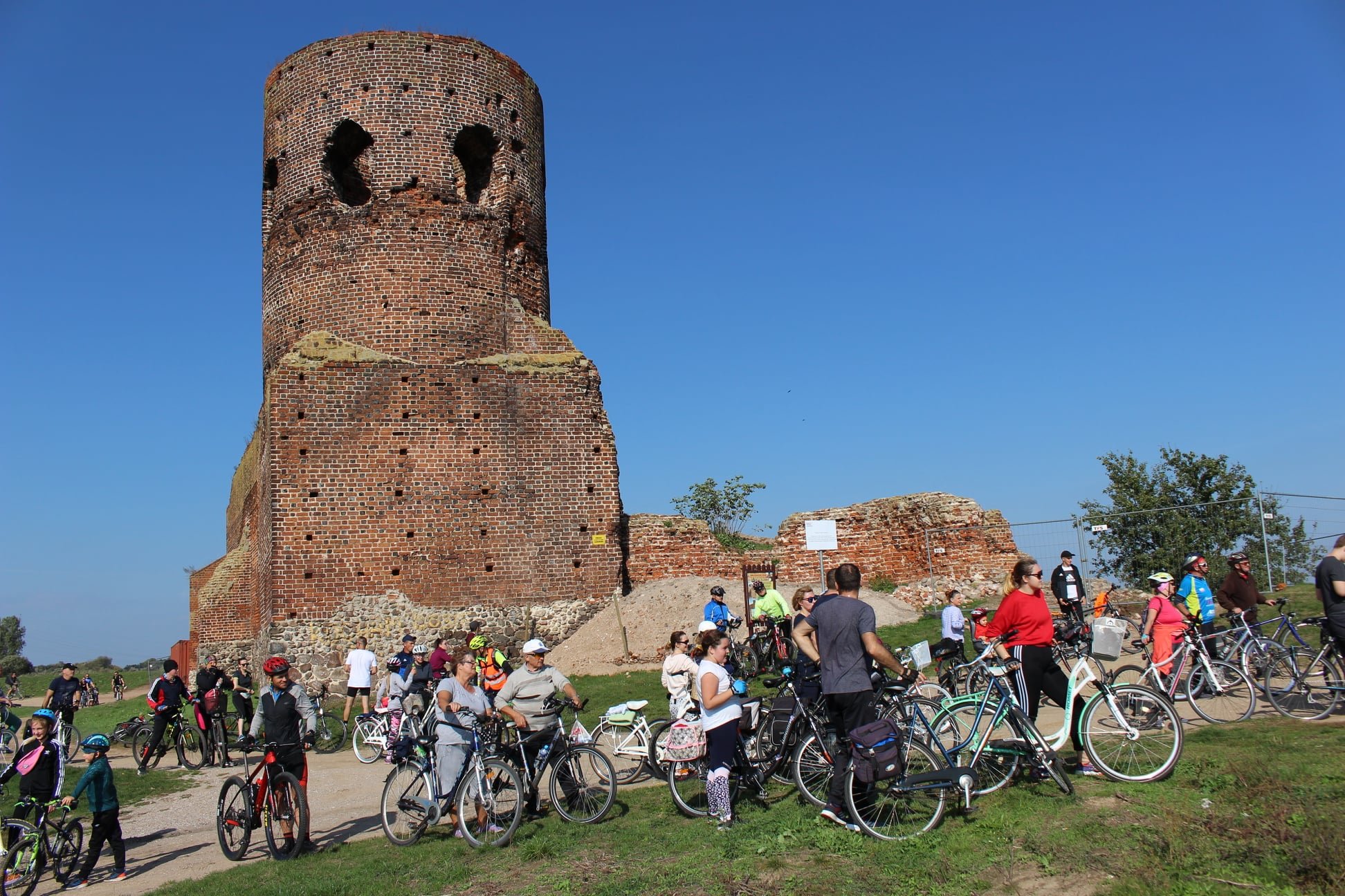 Uczestnicy rajdu rowerowego przy ruinach kolskiego zamku