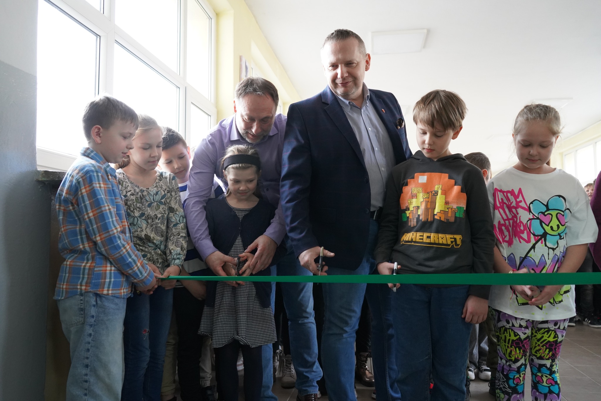 Burmistrz Koła Krzysztof Witkowski, dyrektor Marek Kujawa wraz z uczniami przecinają wstęgę