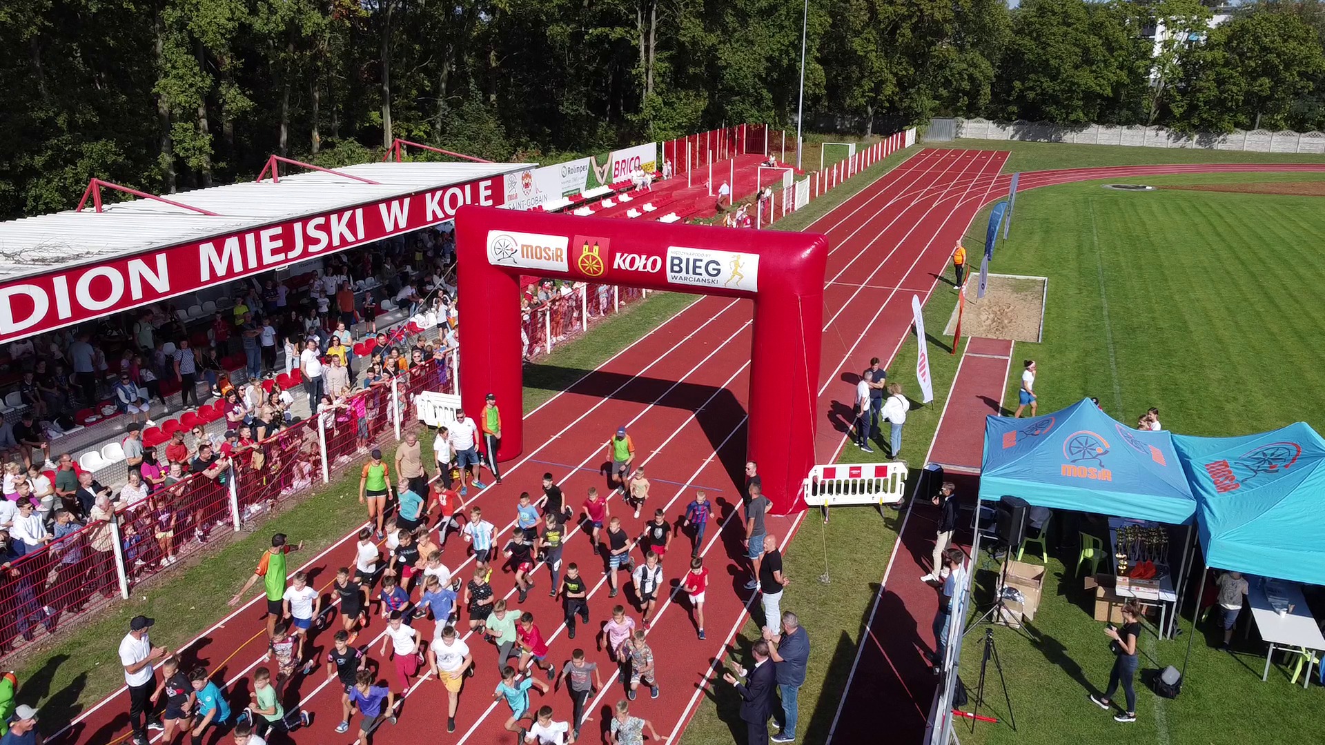 Startujący zawodnicy biegów dziecięcych i młodzieżowych z lotu ptaka na stadionie miejskim w Kole