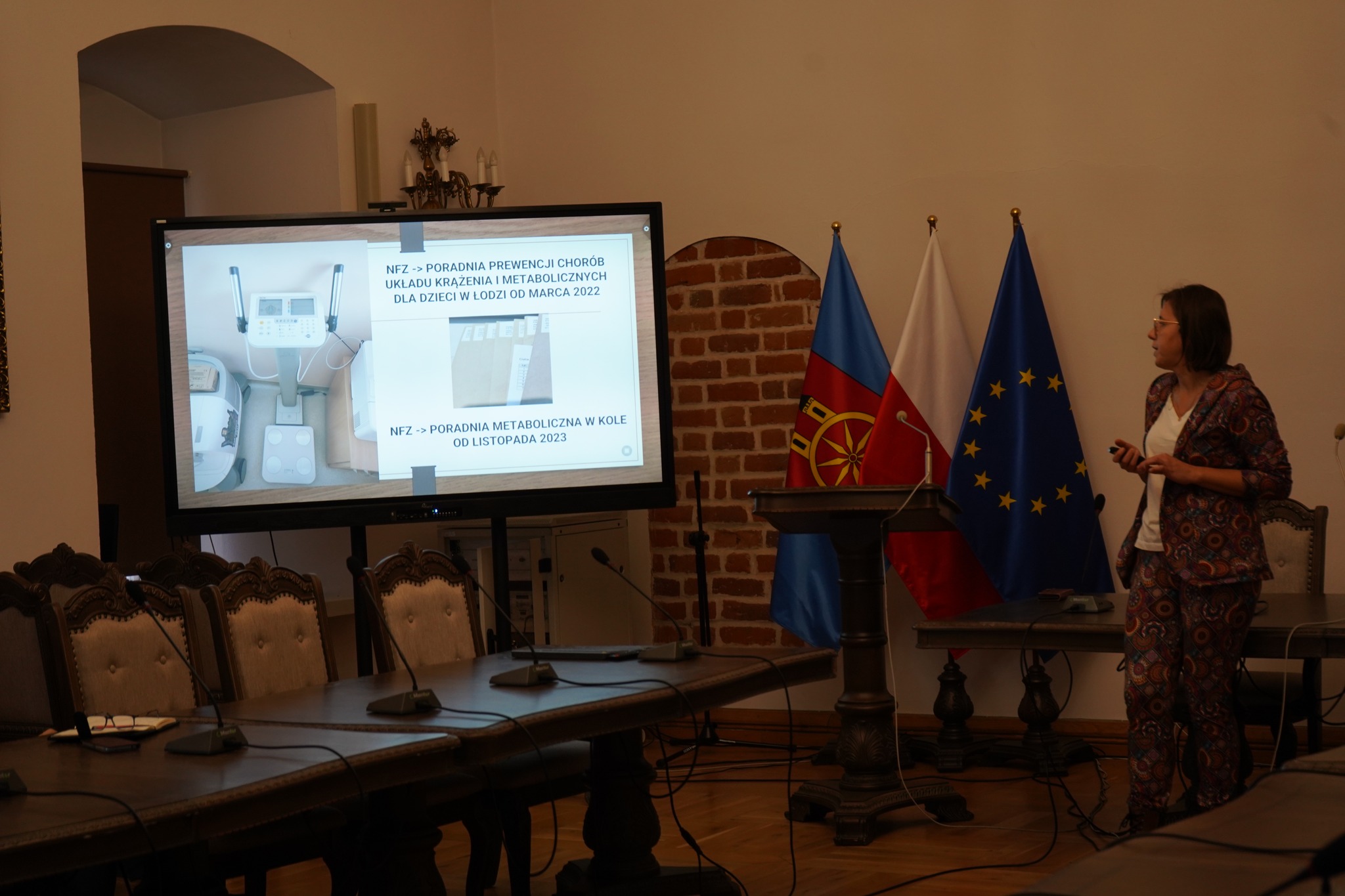Sala sesyjna w Ratuszu w Kole, prelegentka stoi przy ekranie z prezentacją