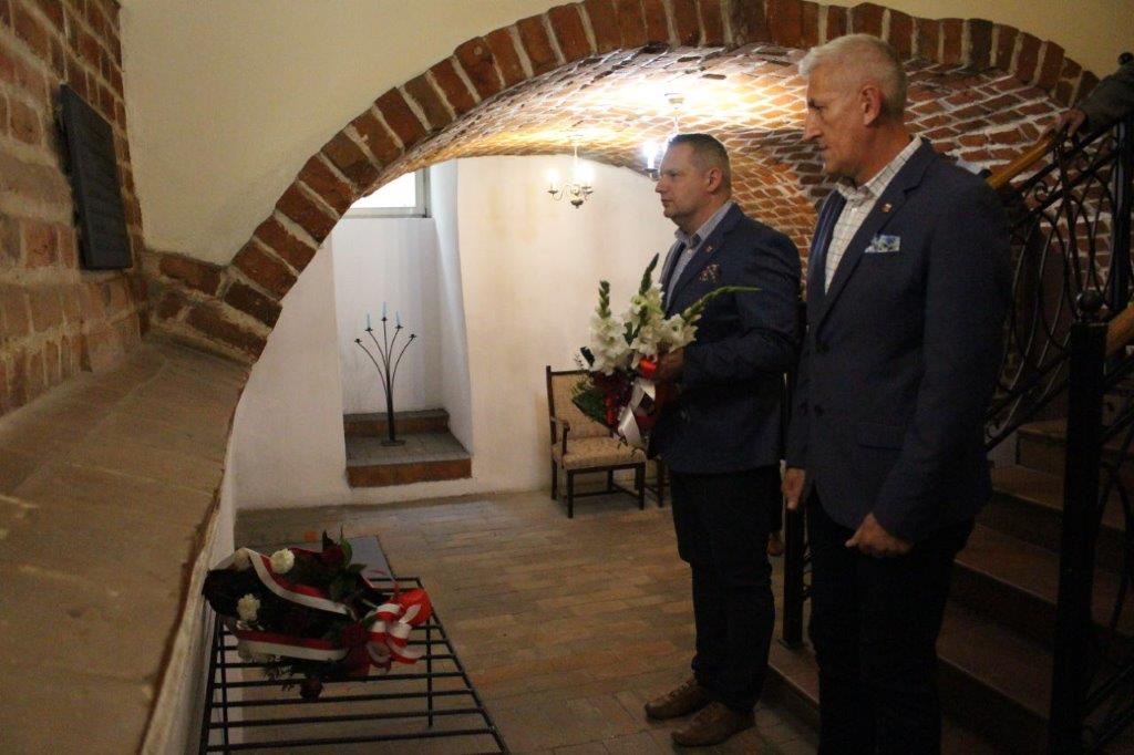 Burmistrz i Zastępca Burmistrza Miasta Koła przed tablicą Michała Beksiaka w podziemiach Ratusza.