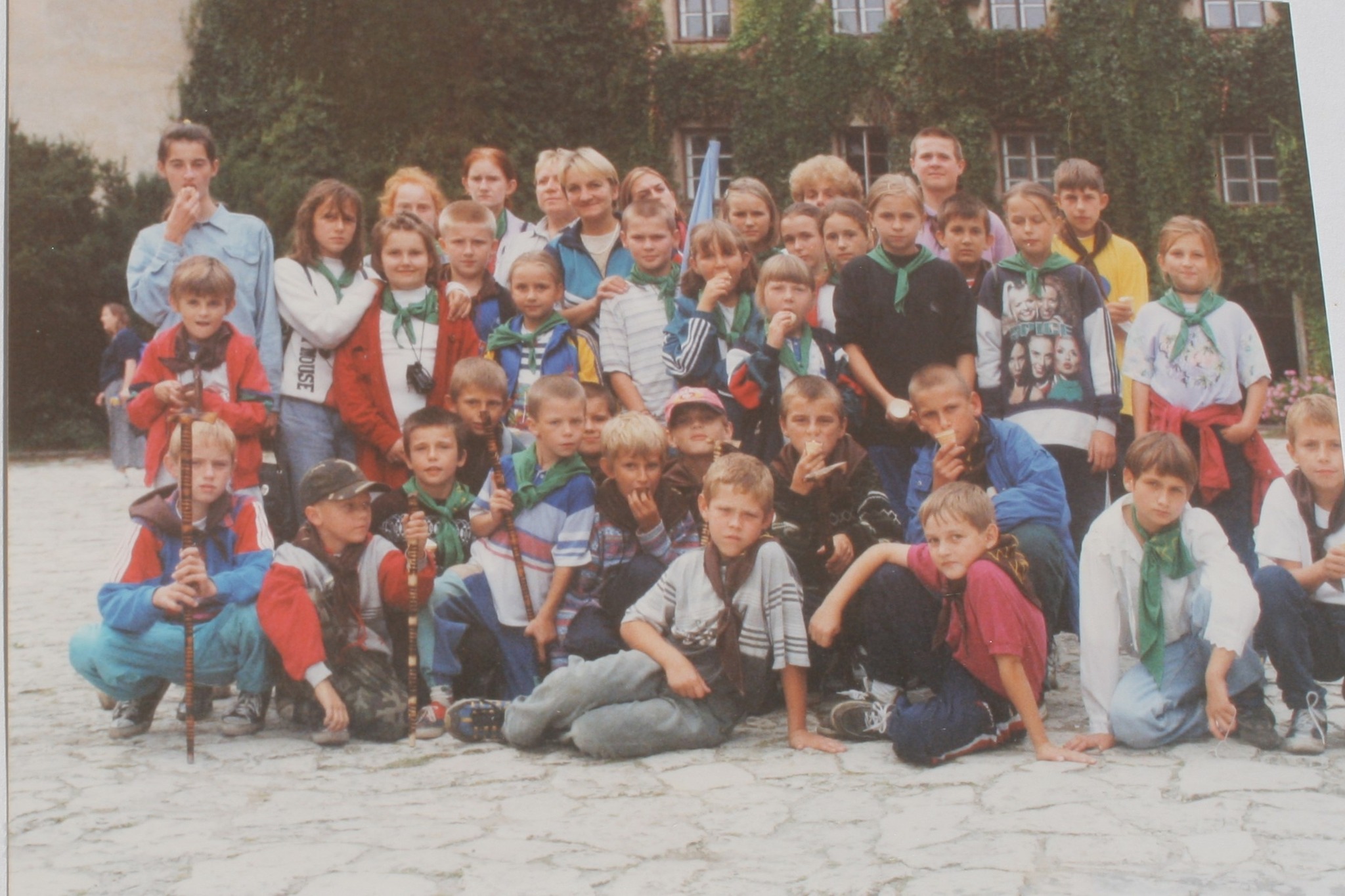 Na zdjęciu widać grupę dzieci i kilku dorosłych pozujących do wspólnego zdjęcia na świeżym powietrzu, podczas wycieczki do źródeł rzeki Warty.