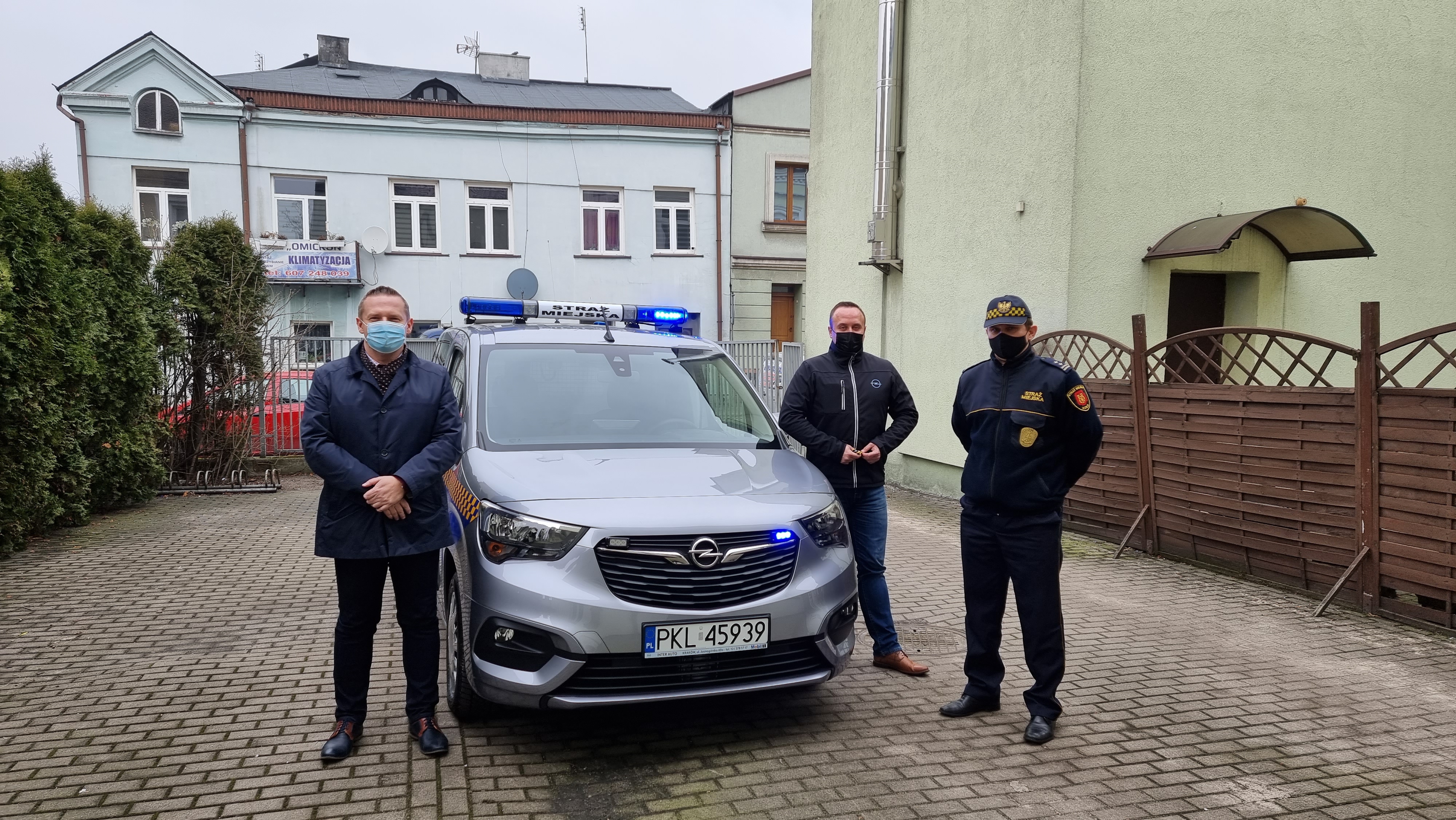 Zdjęcie przedstawia Burmistrza Koła, Komendanta Straży Miejskiej oraz dostawcę przy nowym wozie.