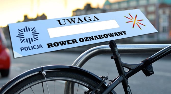 Zdjęcie przedstawia rower z planszą UWAGA ROWER OZNAKOWANY