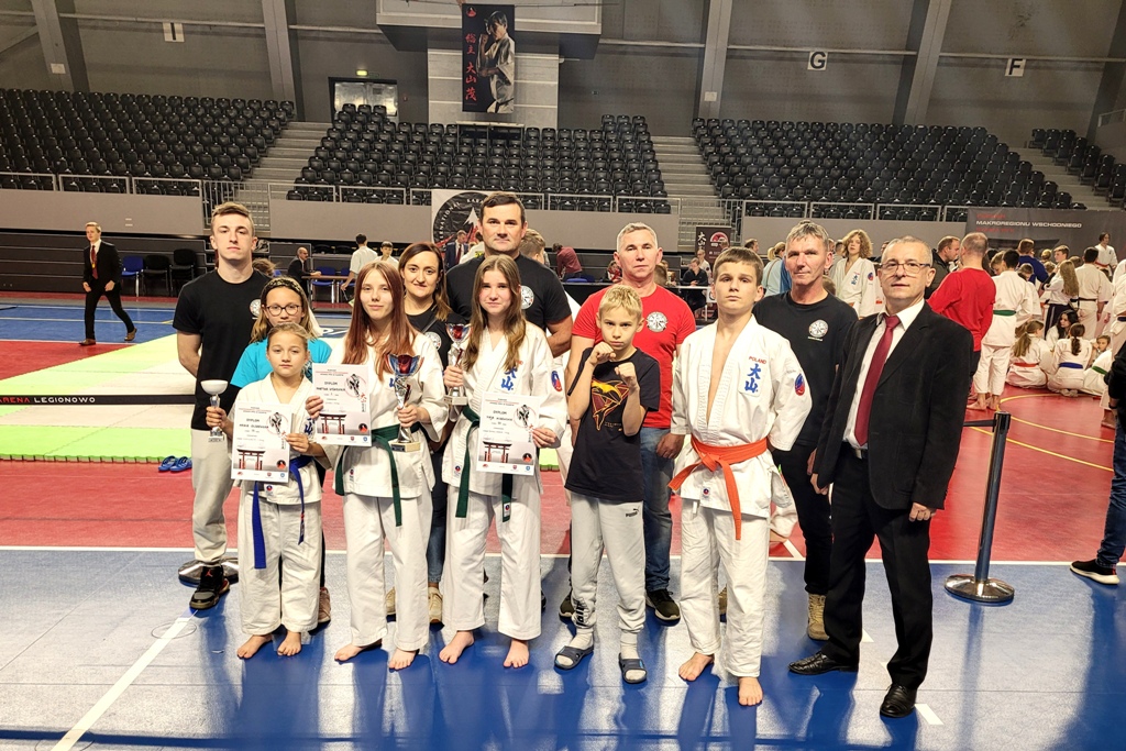Zawodnicy Kolskiego Klubu Sportów Walki z pucharami i dyplomami wraz z opiekunem.