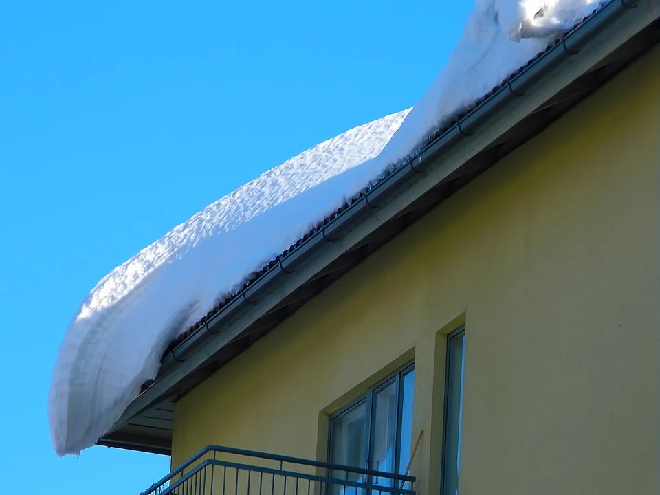 Zdjęcie przedstawia budynek dachu z zalegającym śniegiem.