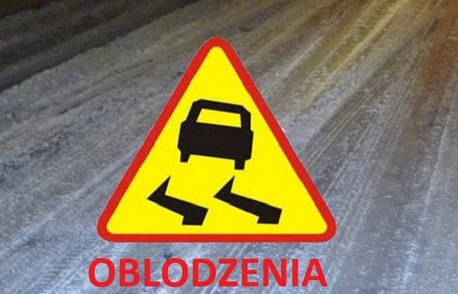 Zdjęcie przedstawia znak drogowy na tle zaśnieżonej ulicy z napisem oblodzenia.