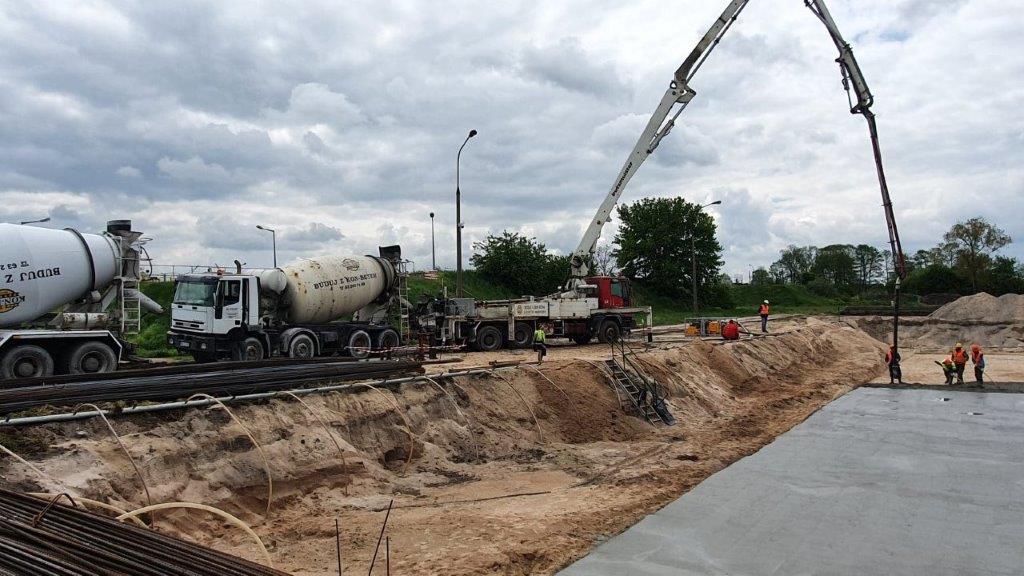 Teren budowy, zalewanie betonem ławy fundamentowej.