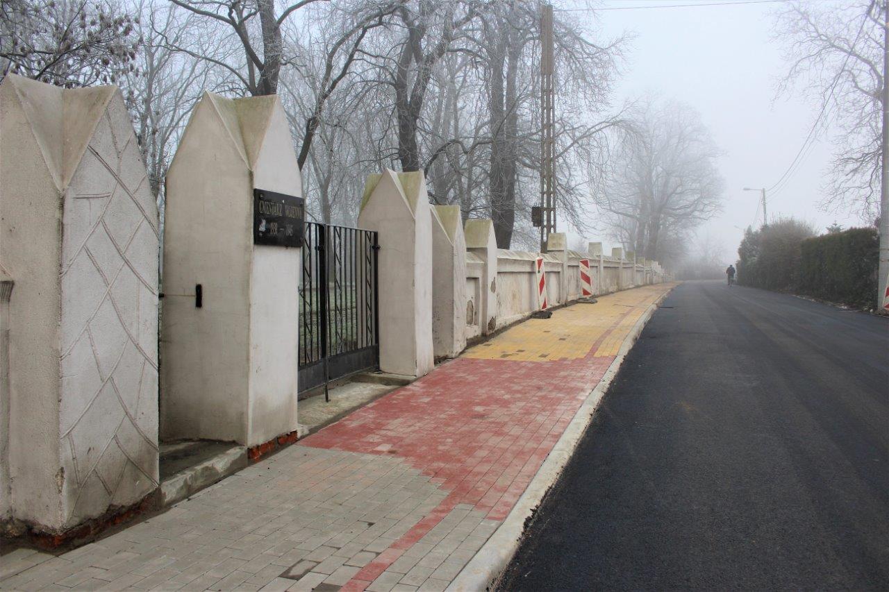 Zdjęcie przedstawia nowy chodnik z betonowej kostki brukowej z nową nawierzchnią ulicy.