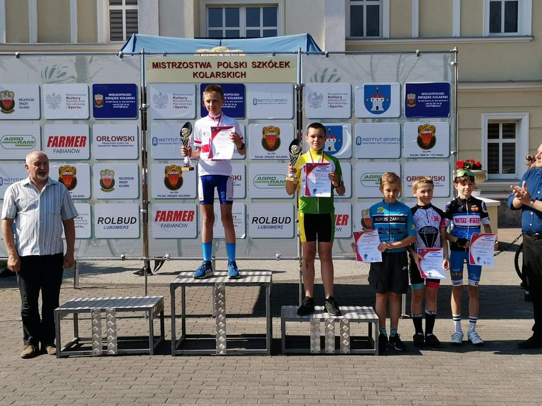 Fabian Dereszyński stoi na podium z pucharem i dyplomem w dłoniach.
