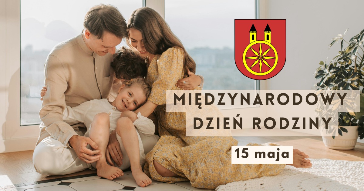 Plansza promująca Międzynarodowy Dzień Rodziny, który przypada 15 maja. W prawym górnym rogu znajduje się herb miasta Koła. W centrum planszy widzimy uśmiechnięta kobietę i mężczyznę z dwójką dzieci, chłopcem i dziewczynką.