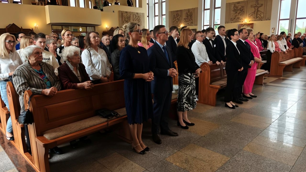 Na zdjęciu widać ludzi zgromadzonych w kościele podczas uroczystości Święto Miasta Koła — stoją w ławkach, elegancko ubrani, uczestnicząc w nabożeństwie.